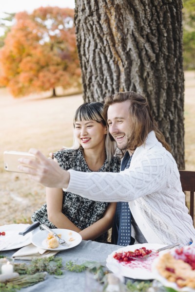 Couple taking selfie at outdoor table