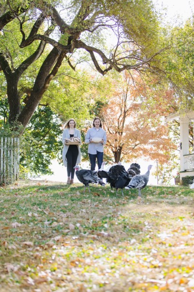 Caucasian couple carrying food in backyard