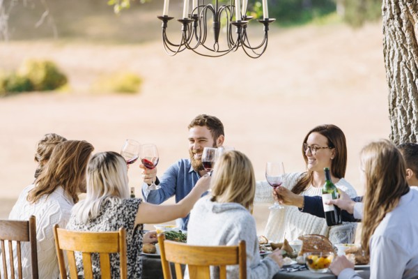 Friends toasting with wine at outdoor table
