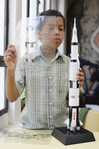 Mixed race boy building model rocket