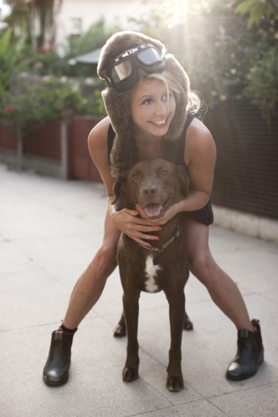 Caucasian woman in fur hat riding dog