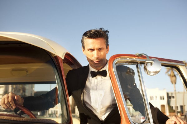 Caucasian man in tuxedo getting into car