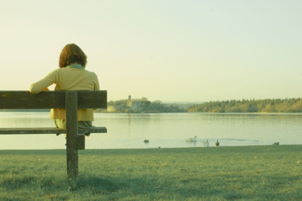 Caucasian teenage girl sitting on park bench