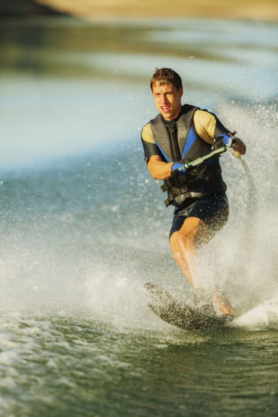 Caucasian man water skiing on lake