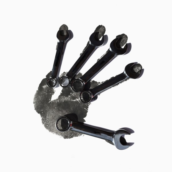 Wrenches over black handprint