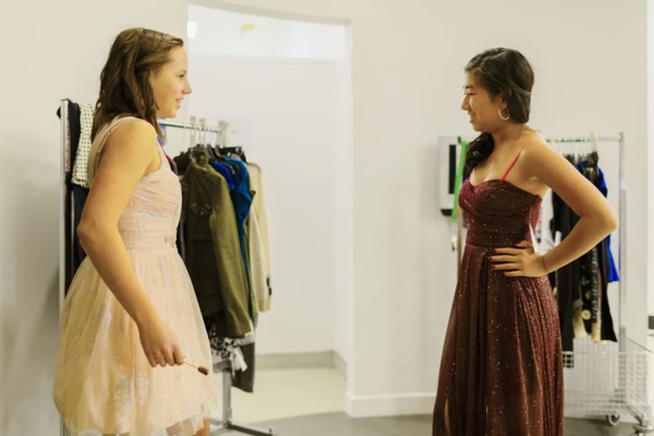 Girls trying on prom dresses in clothing store