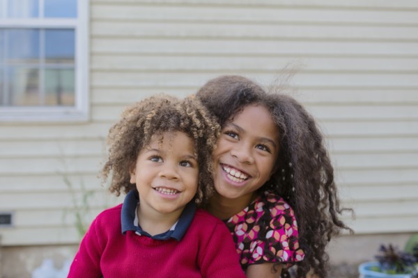 Pacific Islander brother and sister hugging outdoors