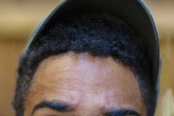 Close up of forehead and baseball cap of mixed race man