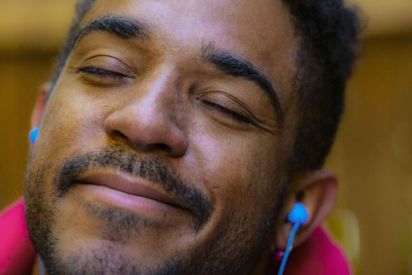 Close up of calm mixed race man listening to earbud