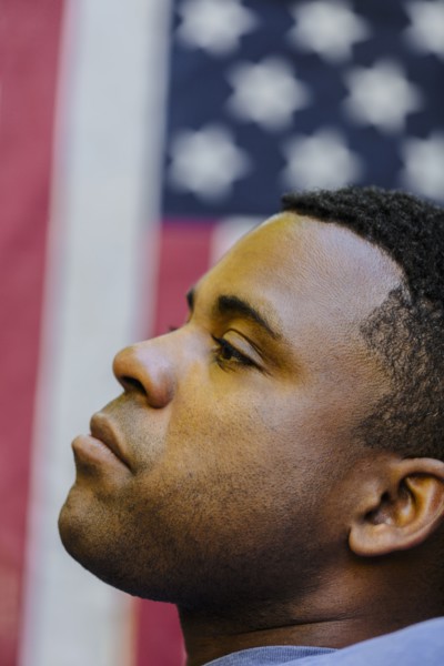 Profile of Black man in front of American flag