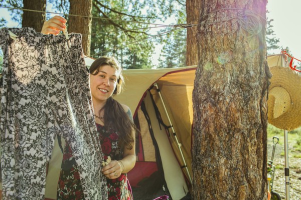 Caucasian woman hanging laundry at campsite