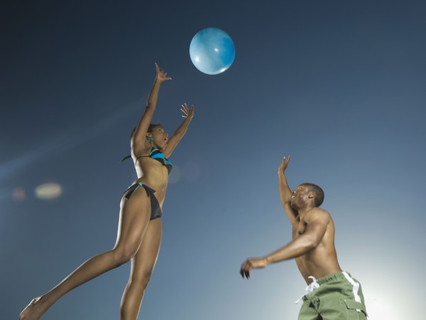 African American couple playing with beach ball