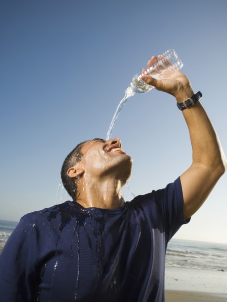 Hispanic man pouring water over head
