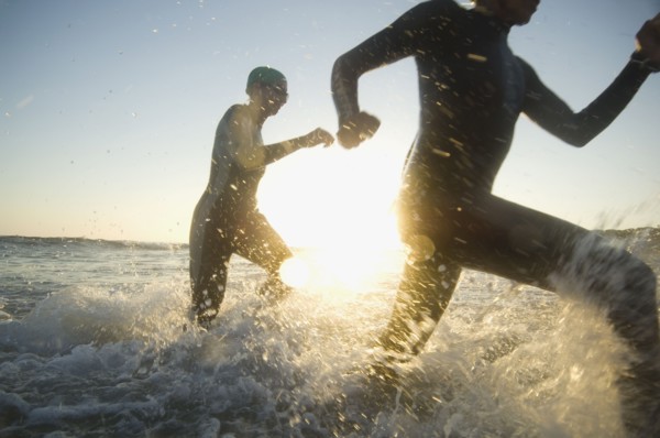 Multi-ethnic swimmers running in surf