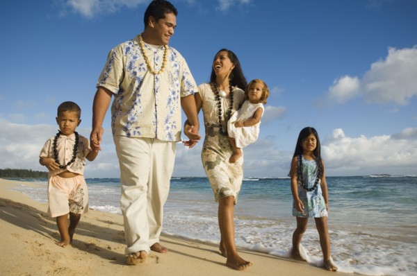 Pacific Islander family walking on beach