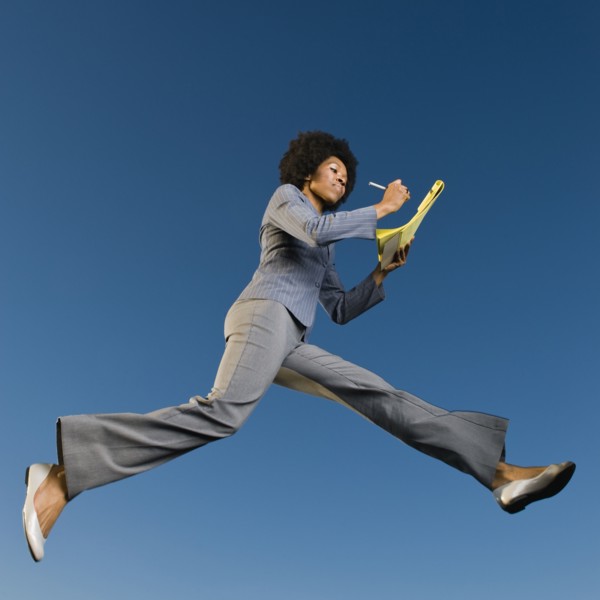 African businesswoman writing on legal pad in mid-air
