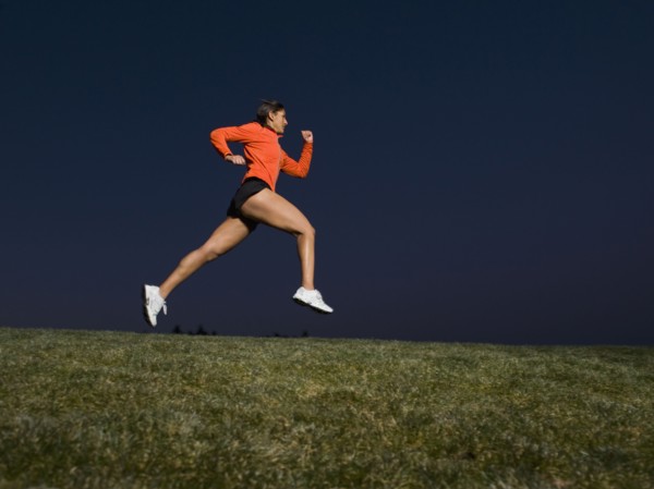 Mixed race woman running on grass
