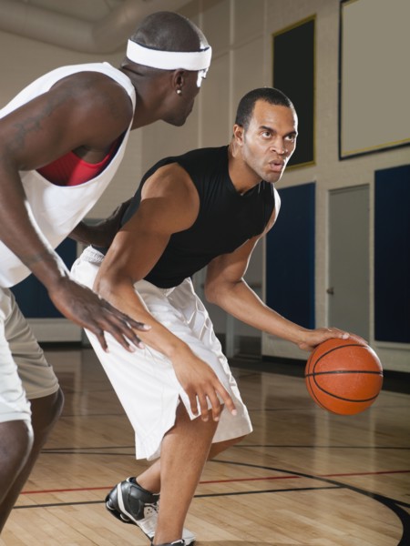 Men playing basketball on basketball court