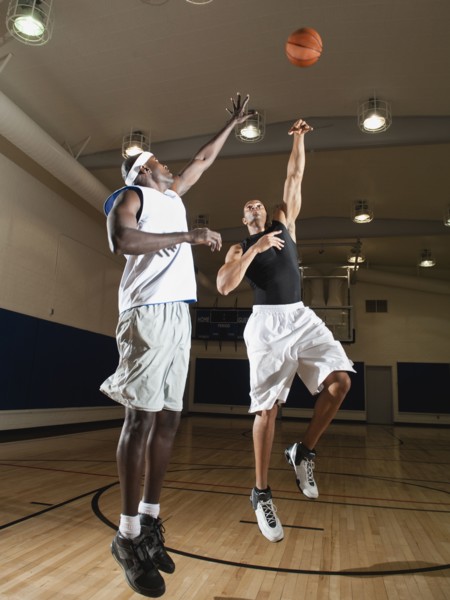 Men playing basketball on basketball court