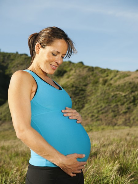 Pregnant Hispanic woman caressing her stomach