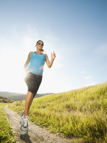 Pregnant Hispanic woman running in remote area