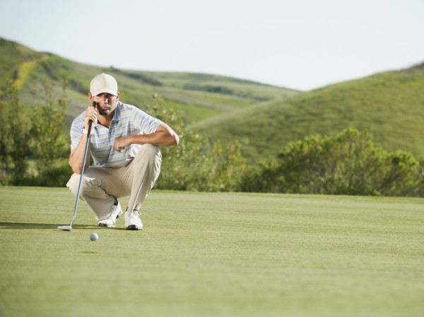 Caucasian golfer checking the ground on golf course
