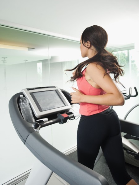 Mixed race woman running on treadmill
