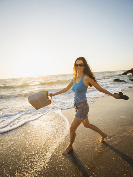 Mixed race woman walking on beach