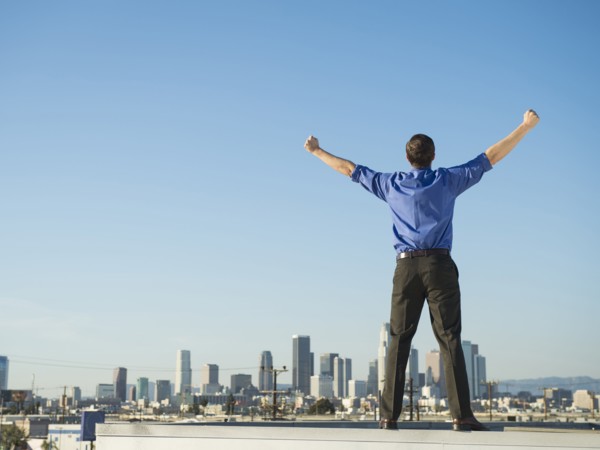 Caucasian businessman standing on urban rooftop