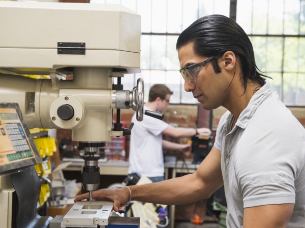 Workers using machinery in machine shop