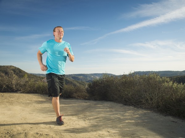 Caucasian man jogging on hilltop