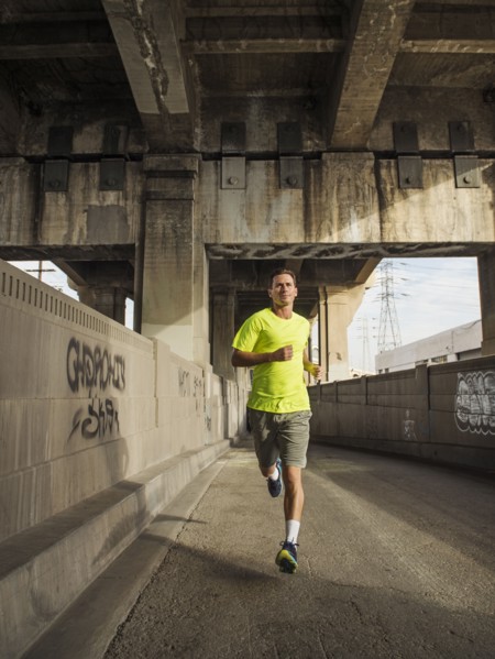 Caucasian man running in urban tunnel