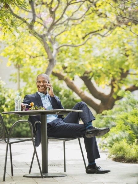 Black businessman working and eating lunch outdoors