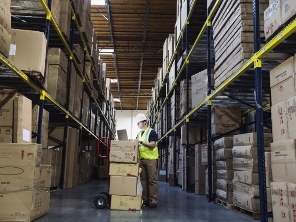 Caucasian worker using laptop in warehouse