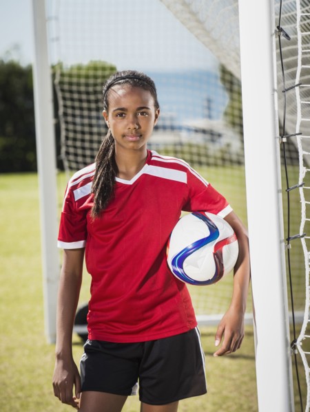Mixed race soccer player standing in goal