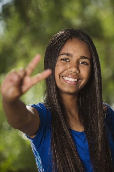 Mixed race girl giving peace sign