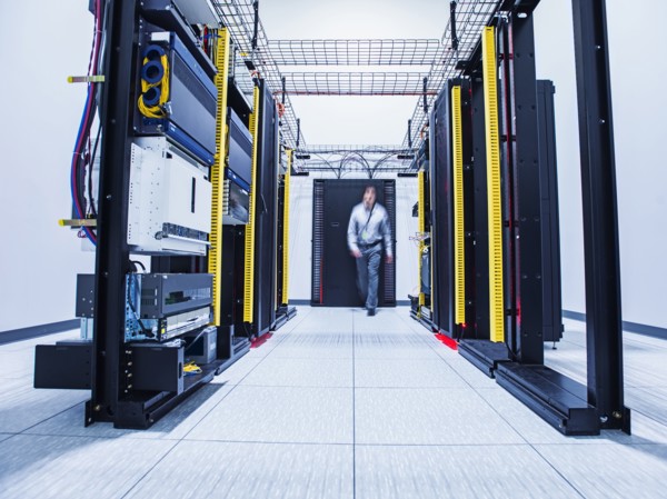 Blurred view of Hispanic technician walking in server room