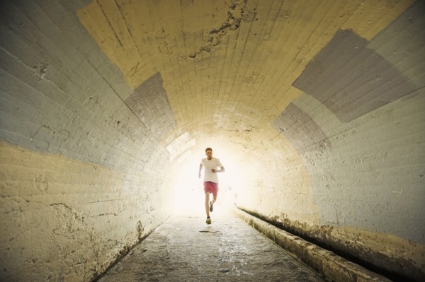 Caucasian man jogging in tunnel
