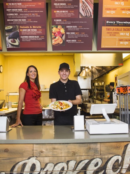 Hispanic server and businesswoman smiling in cafe