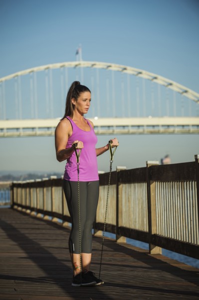 Caucasian woman working out on urban bridge