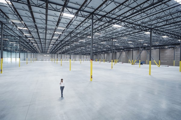 Indian businessman talking on cell phone in empty warehouse