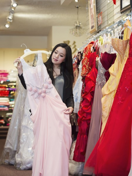 Smiling Chinese woman shopping for dress
