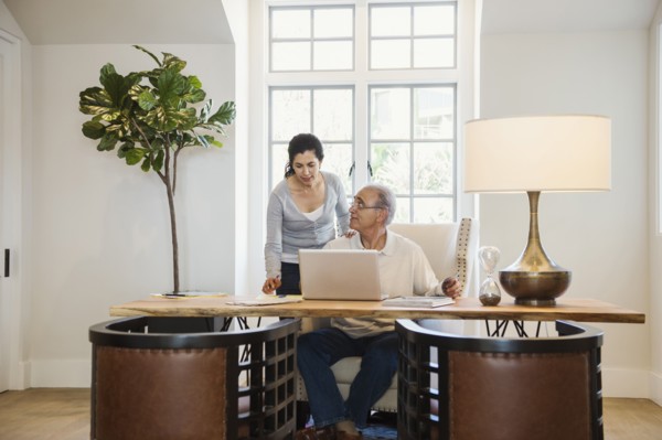 Older couple using laptop in home office