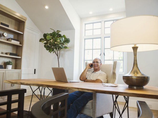 Caucasian man talking on cell phone in home office