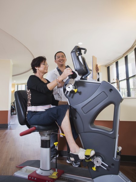 Physical therapist watching patient on exercise machine
