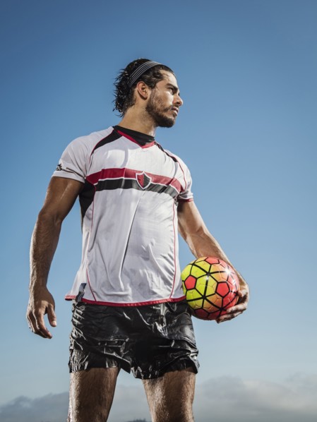 Hispanic man holding soccer ball