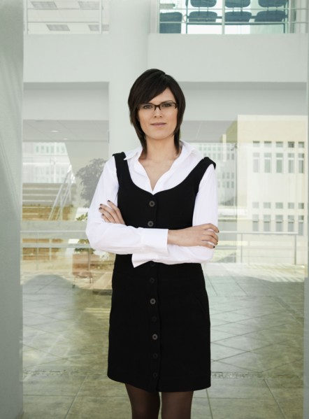 Hispanic businesswoman standing in office lobby