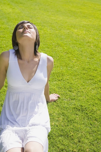 Hispanic woman relaxing on grass