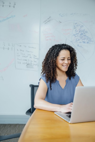Mixed race businesswoman using laptop