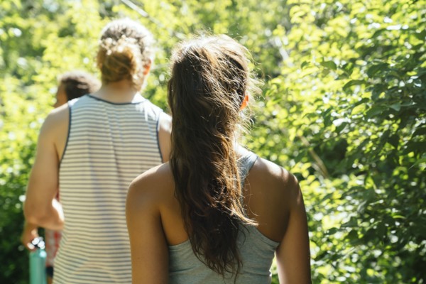 Rear view of friends walking near trees